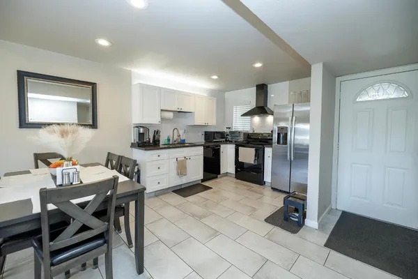a kitchen with a dining table chairs and refrigerator