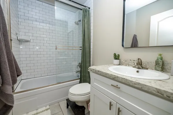a bathroom with a granite countertop toilet sink and mirror