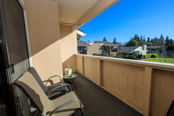 a view of a balcony with chair and wooden fence