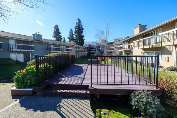 a view of a patio with table and chairs potted plants and wooden fence