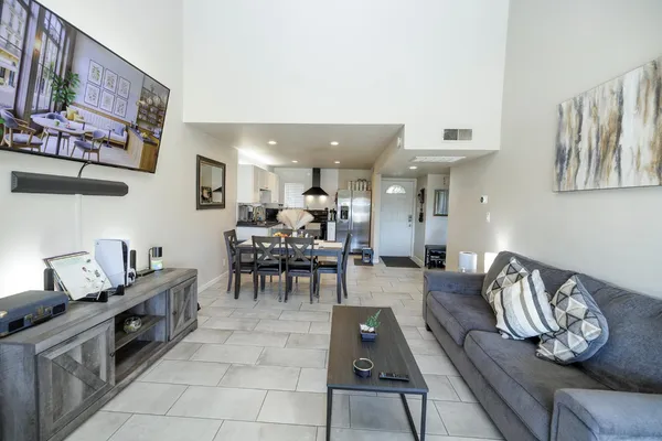 a living room with furniture and a view of kitchen