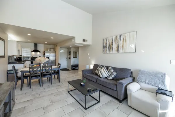 a living room with furniture a dining table and kitchen view