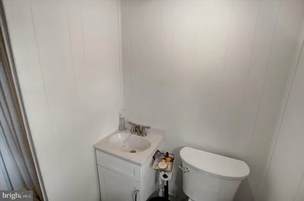 a white toilet sitting next to a white sink and vanity