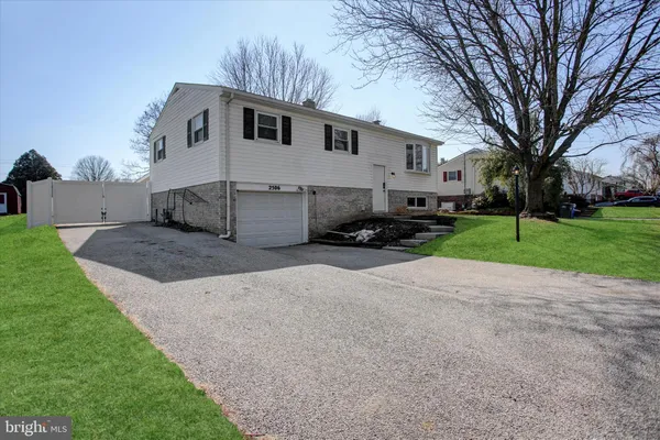 a white house that has a tree in front of it