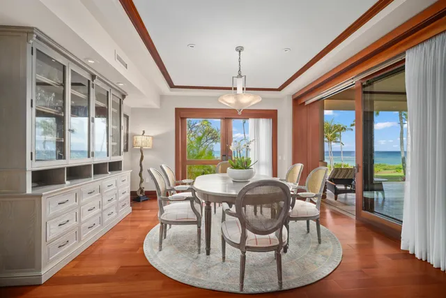 a dining room with furniture a chandelier and wooden floor