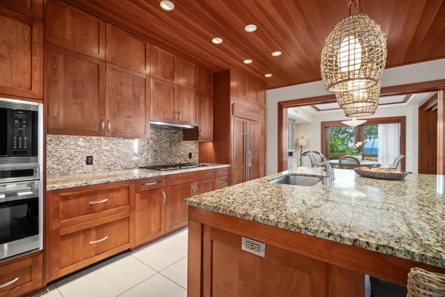 a kitchen with kitchen island granite countertop wooden cabinets a sink and dishwasher
