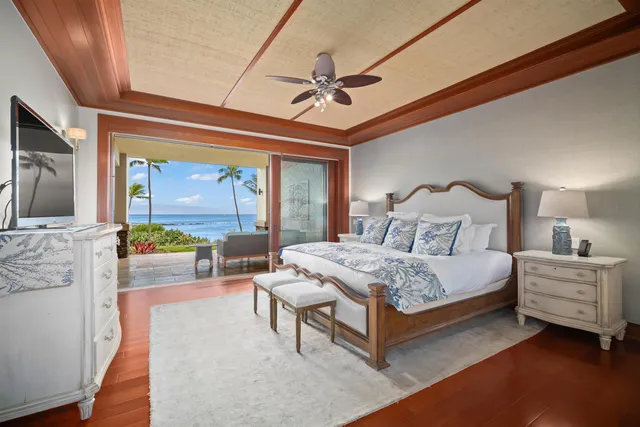 a bedroom with a bed a chandelier and next to a window