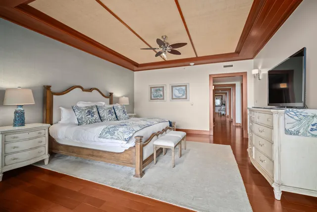 a bedroom with a bed a flat screen tv and dresser