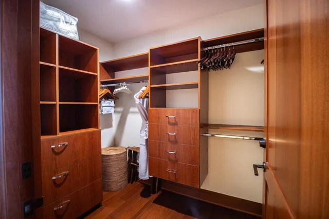 a view of walk in closet with clothes and shoes