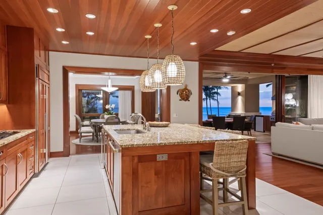 a dining hall with stainless steel appliances granite countertop wooden cabinets a dining table and chairs