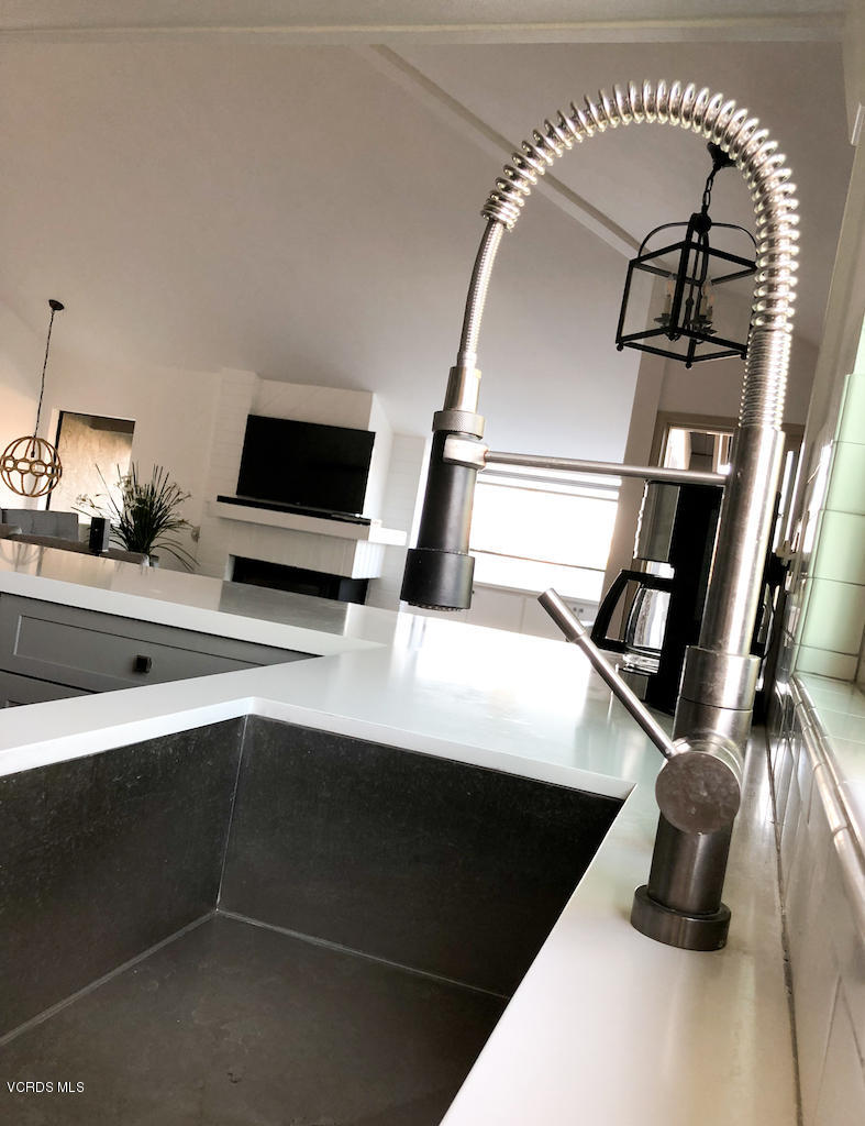 3624 Sunset Lane Oxnard, CA 93035 - Photo 14 of 26 a kitchen with a sink a faucet a fireplace and cabinets