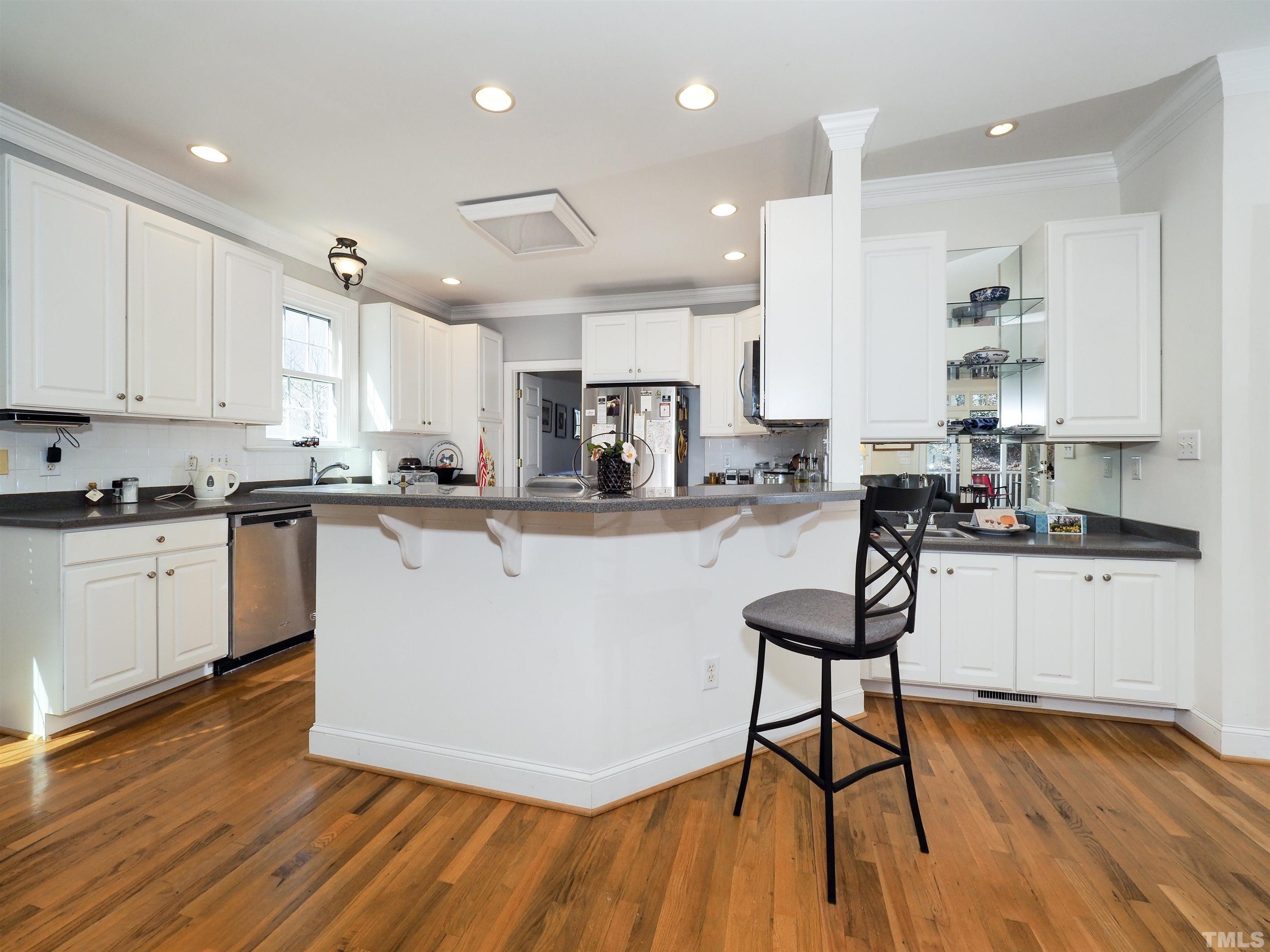 42 Cheswick Place Durham, NC 27707 - Photo 11 of 27 a kitchen with stainless steel appliances granite countertop wooden floors and cabinets