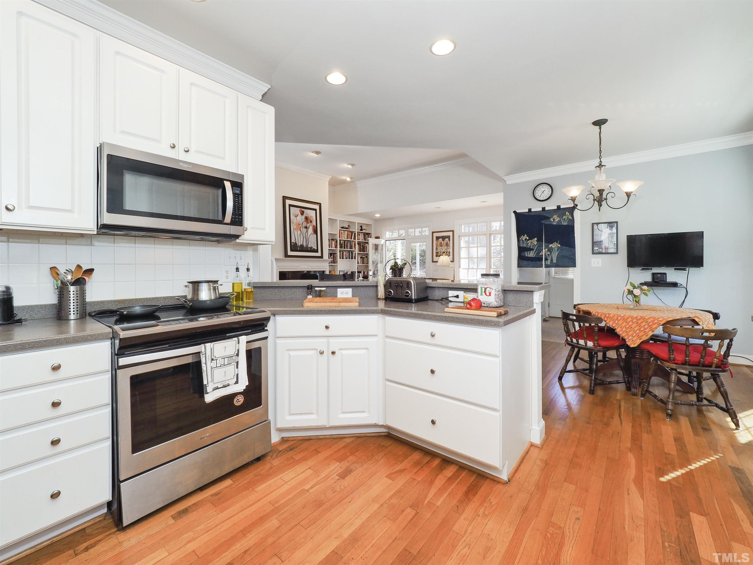 42 Cheswick Place Durham, NC 27707 - Photo 8 of 27 a kitchen with stainless steel appliances granite countertop a stove top oven a sink dishwasher and a microwave oven with wooden floor