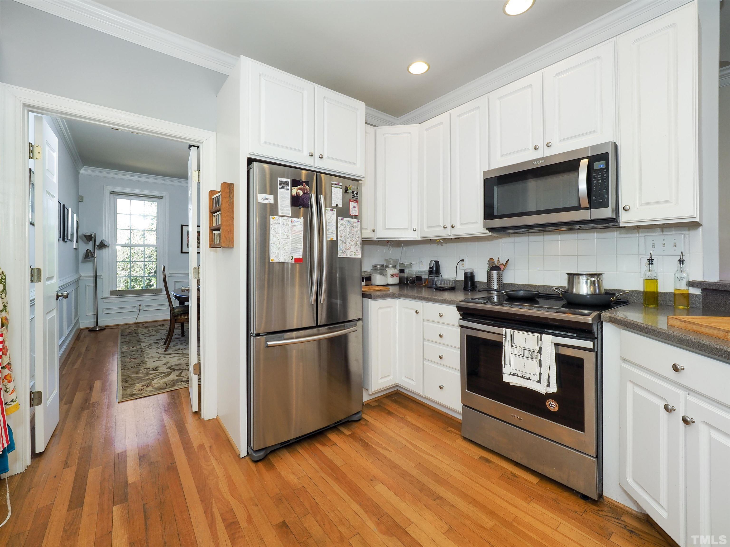 42 Cheswick Place Durham, NC 27707 - Photo 9 of 27 a kitchen with cabinets stainless steel appliances and wooden floor