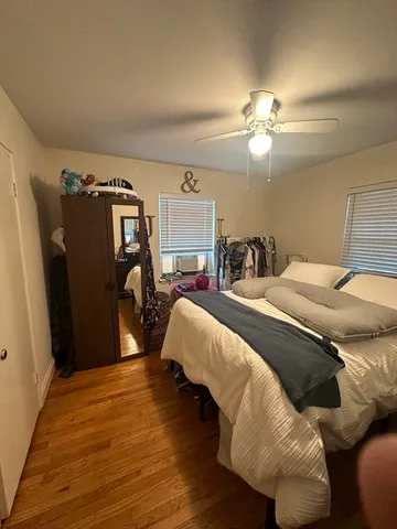 a bedroom with bed and wooden floor