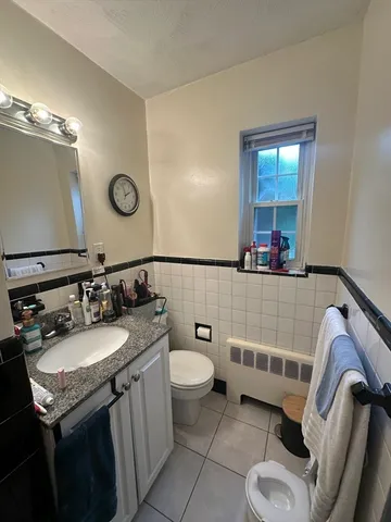 a bathroom with a granite countertop sink mirror vanity and toilet