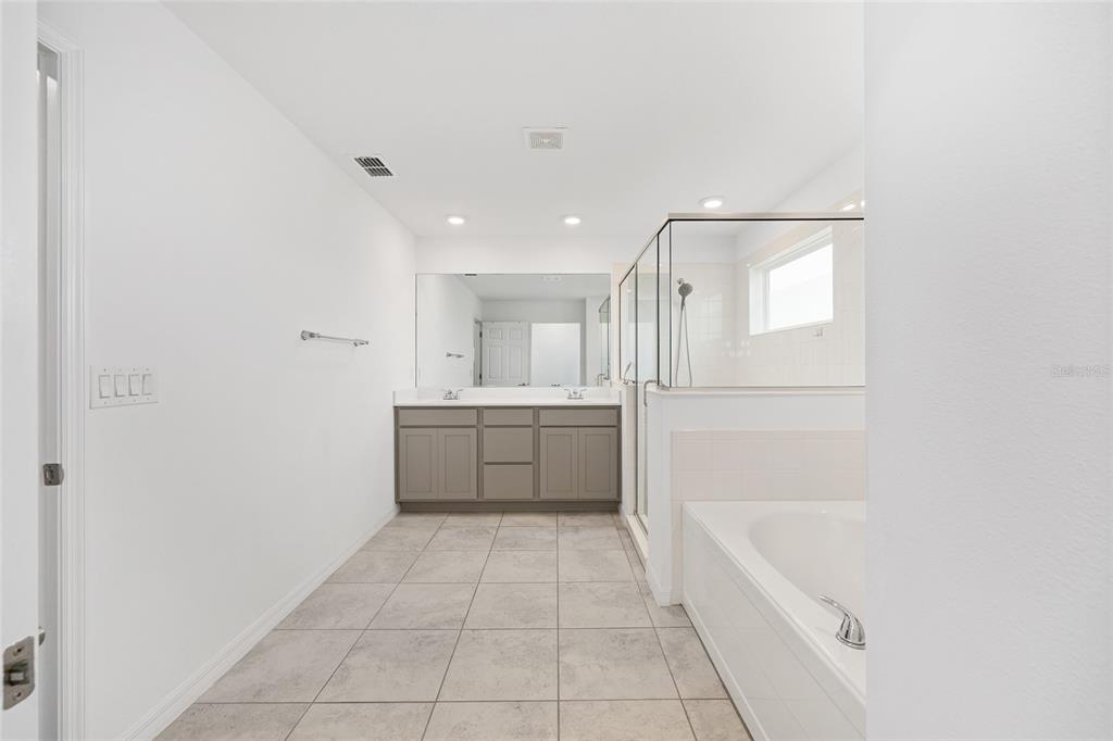 7635 Southwest 64th St Road Ocala, FL 34474 - Photo 50 of 86 a bathroom with a tub a sink a mirror and a shower