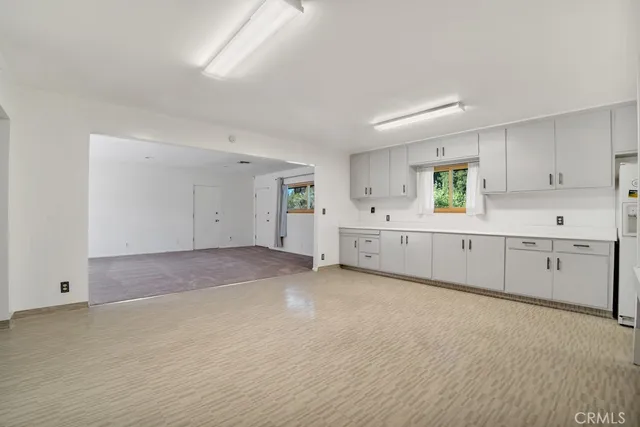 a view of a kitchen with white cabinets and wooden floor