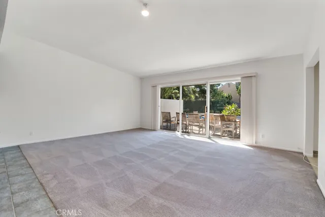 a view of an empty room with glass door and balcony