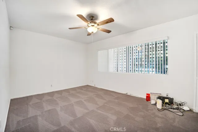 an empty room with a window and a ceiling fan