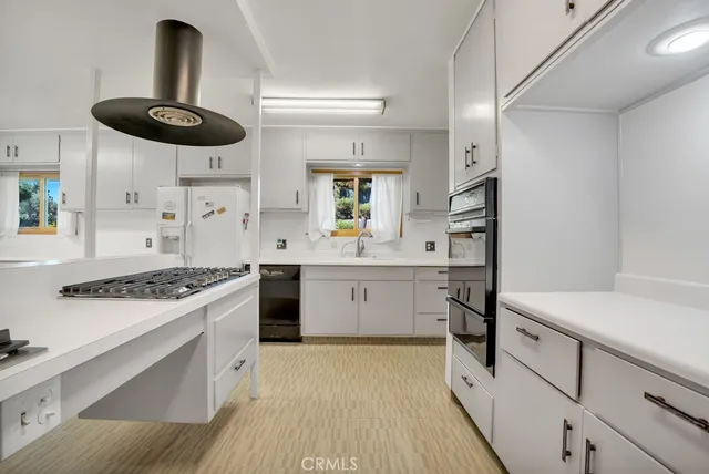 a kitchen with a stove a sink and a refrigerator