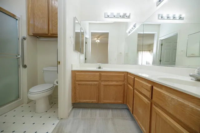 a bathroom with a sink a toilet and shower