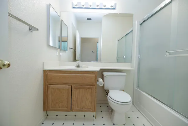 a bathroom with a toilet a sink and mirror