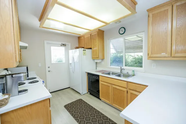 a kitchen with sink refrigerator and window