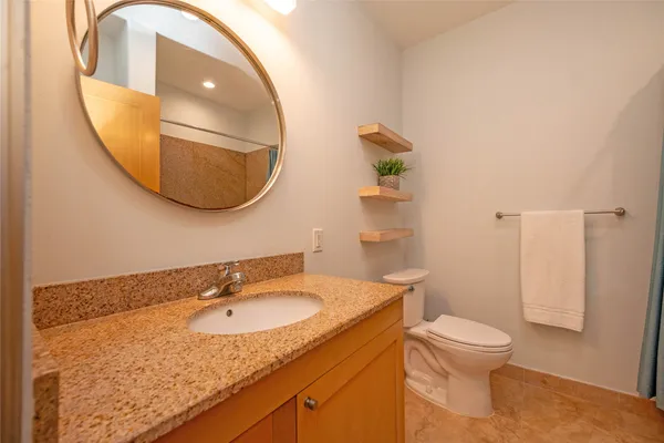 a bathroom with a granite countertop sink and a mirror