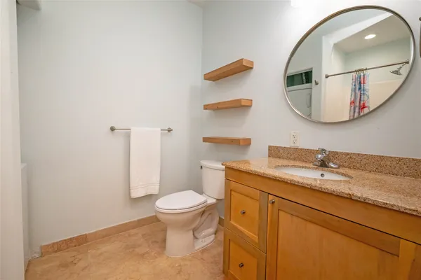 a bathroom with a granite countertop sink and a mirror