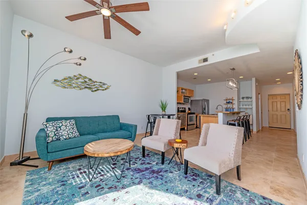 a living room with furniture a rug and a chandelier
