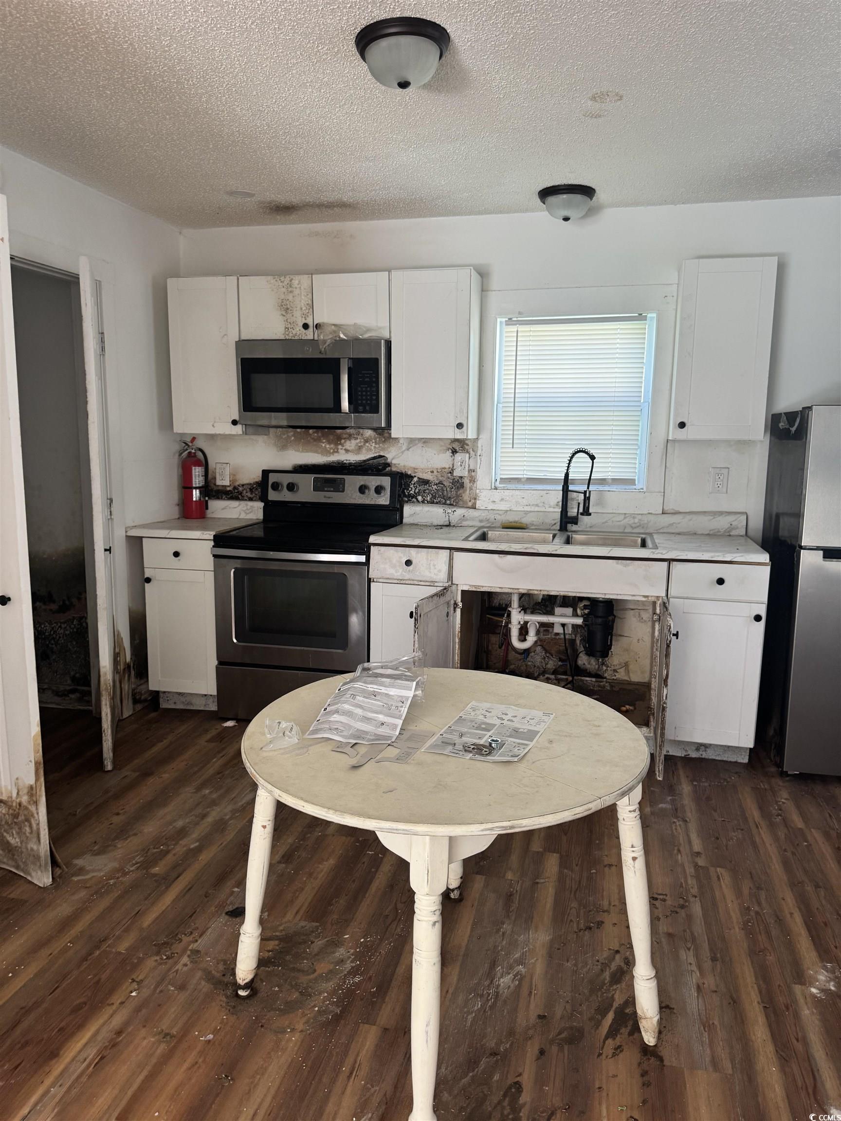 809 North Dargan Street Florence, SC 29506 - Photo 8 of 13 Kitchen with white cabinetry, light countertops, a textured ceiling, and stainless steel appliances