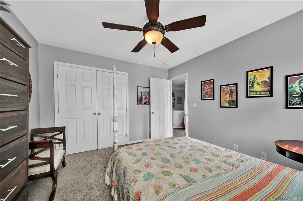 720 Warwick Way Fort Mill, SC 29708 - Photo 26 of 36 a bedroom with a bed and a chandelier