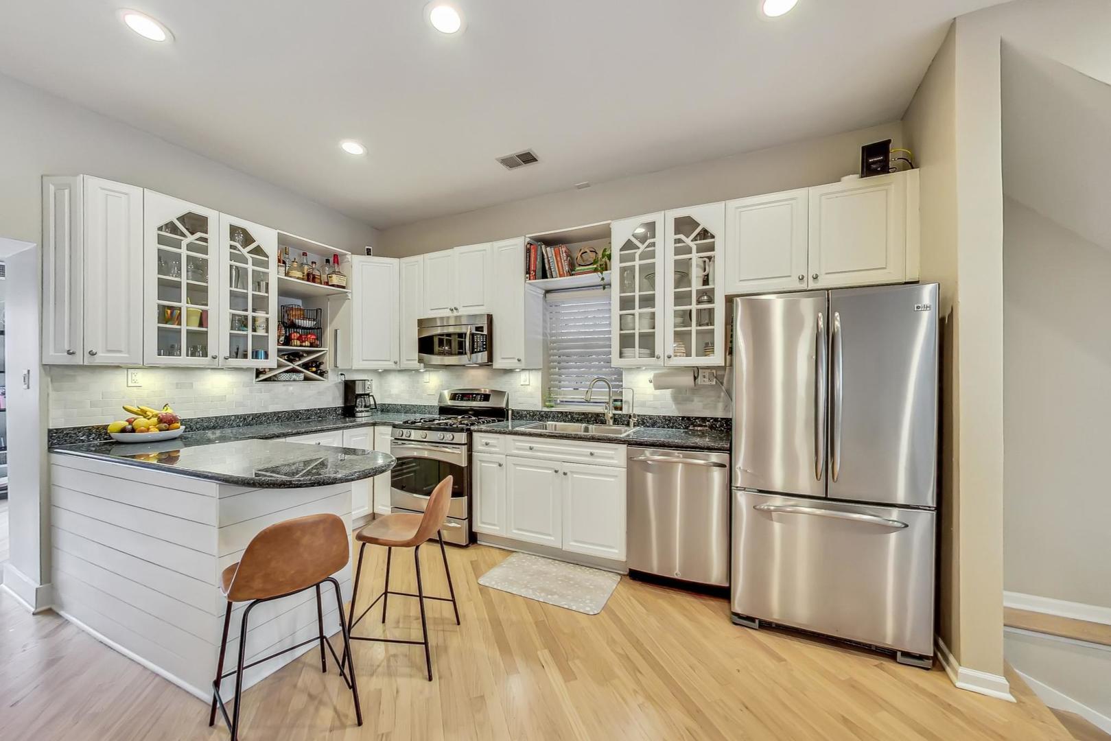 2320 West Belden Avenue Chicago, IL 60647 - Photo 5 of 36 a kitchen with stainless steel appliances granite countertop a refrigerator a stove a sink and white cabinets with wooden floor