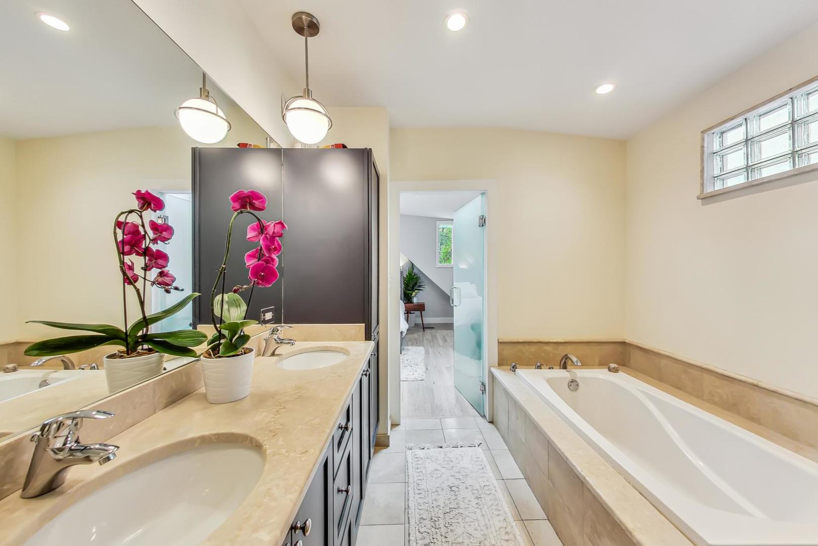 2320 West Belden Avenue Chicago, IL 60647 - Photo 10 of 36 a bathroom with a granite countertop sink a bathtub and a mirror