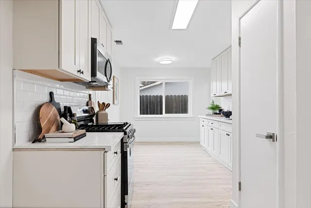a kitchen that has a sink cabinets and a window