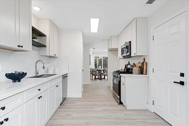 a kitchen with cabinets and wooden floor