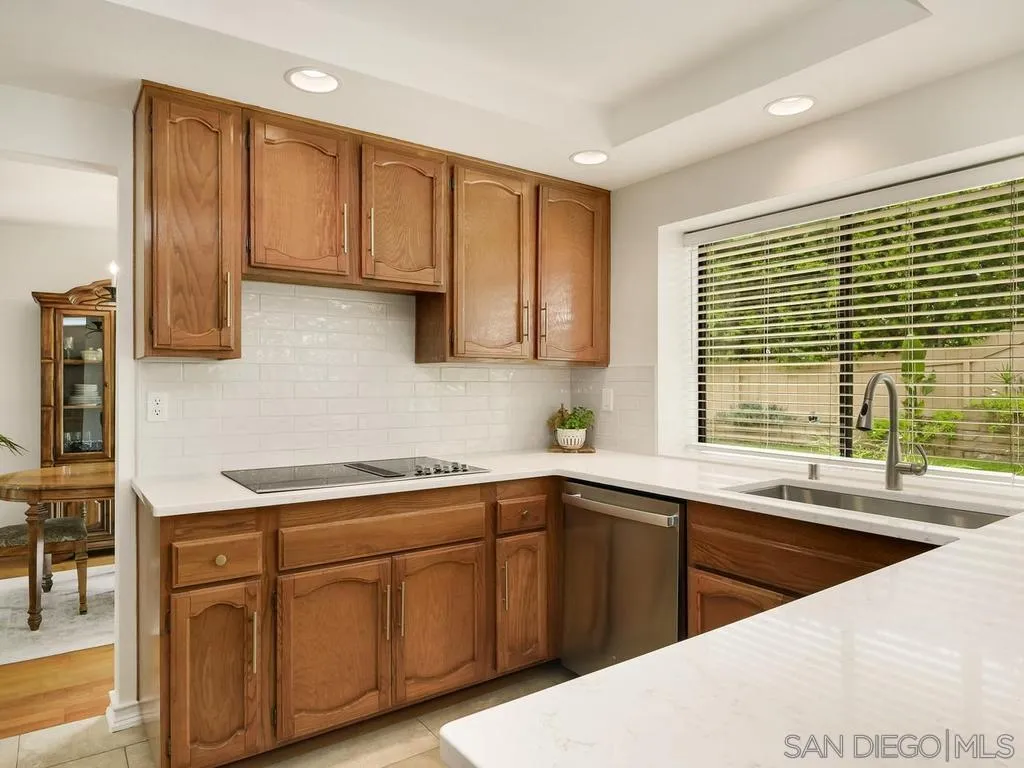 1981 Avenida Joaquin Encinitas, CA 92024 - Photo 15 of 51 a kitchen with a sink dishwasher a stove and white cabinets with wooden floor