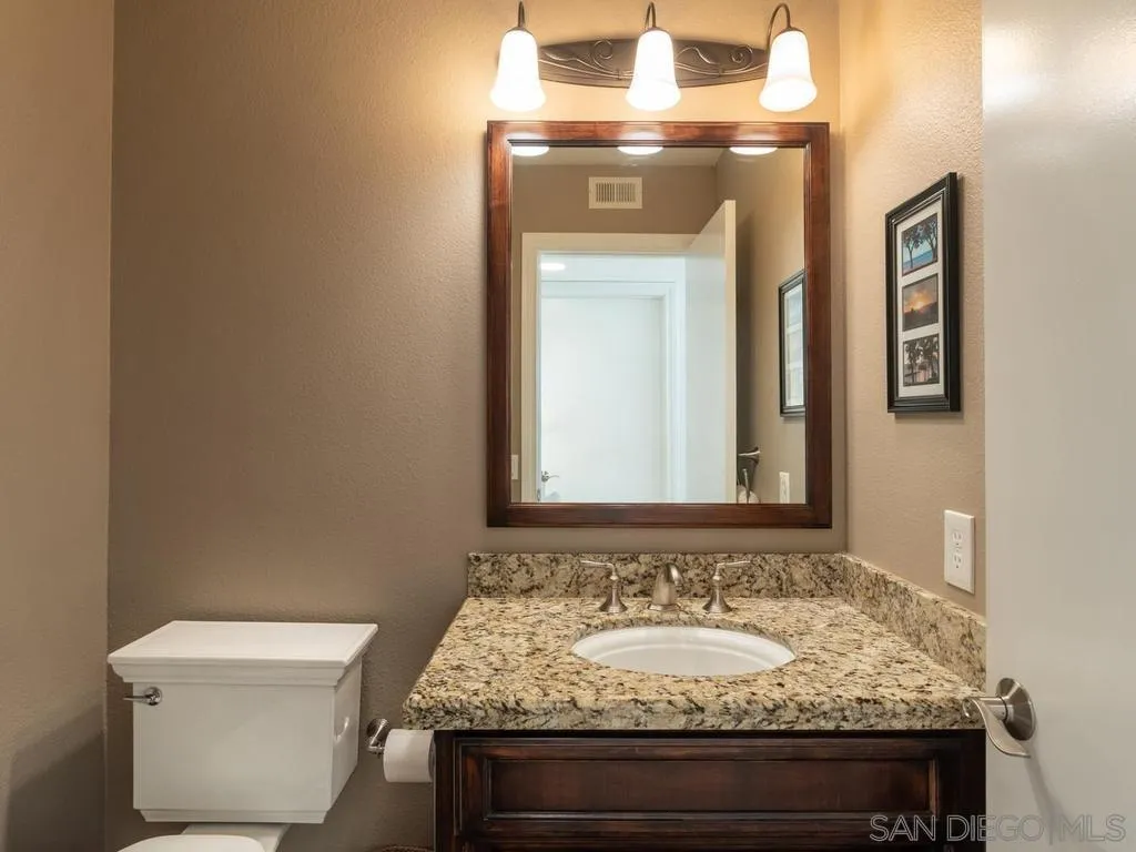 1981 Avenida Joaquin Encinitas, CA 92024 - Photo 22 of 51 a bathroom with a granite countertop toilet sink and mirror