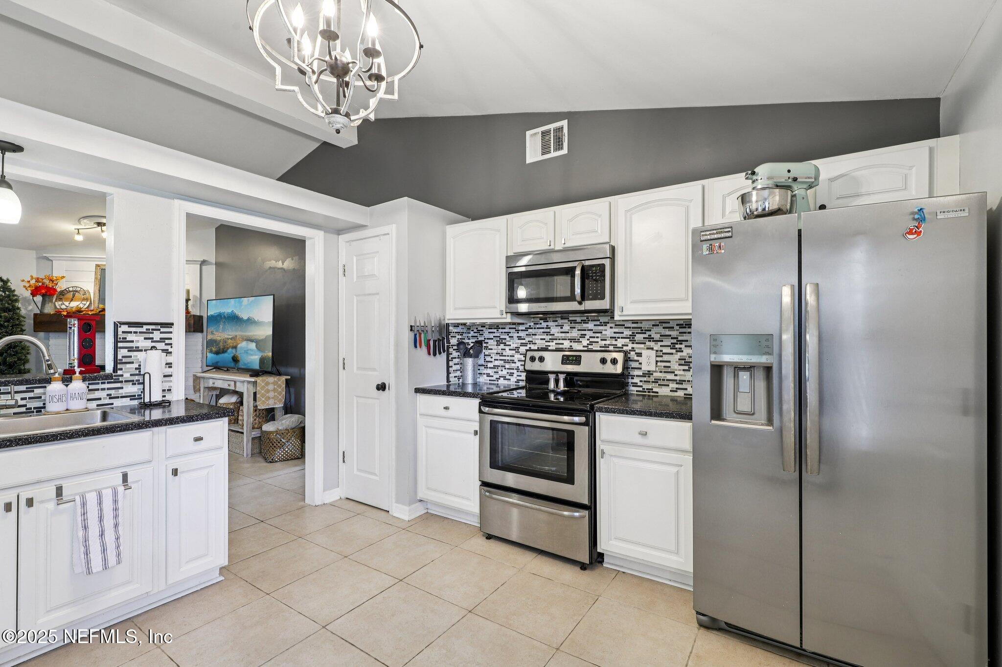 8053 Queensferry Lane Jacksonville, FL 32244 - Photo 14 of 45 a kitchen with cabinets stainless steel appliances and a chandelier