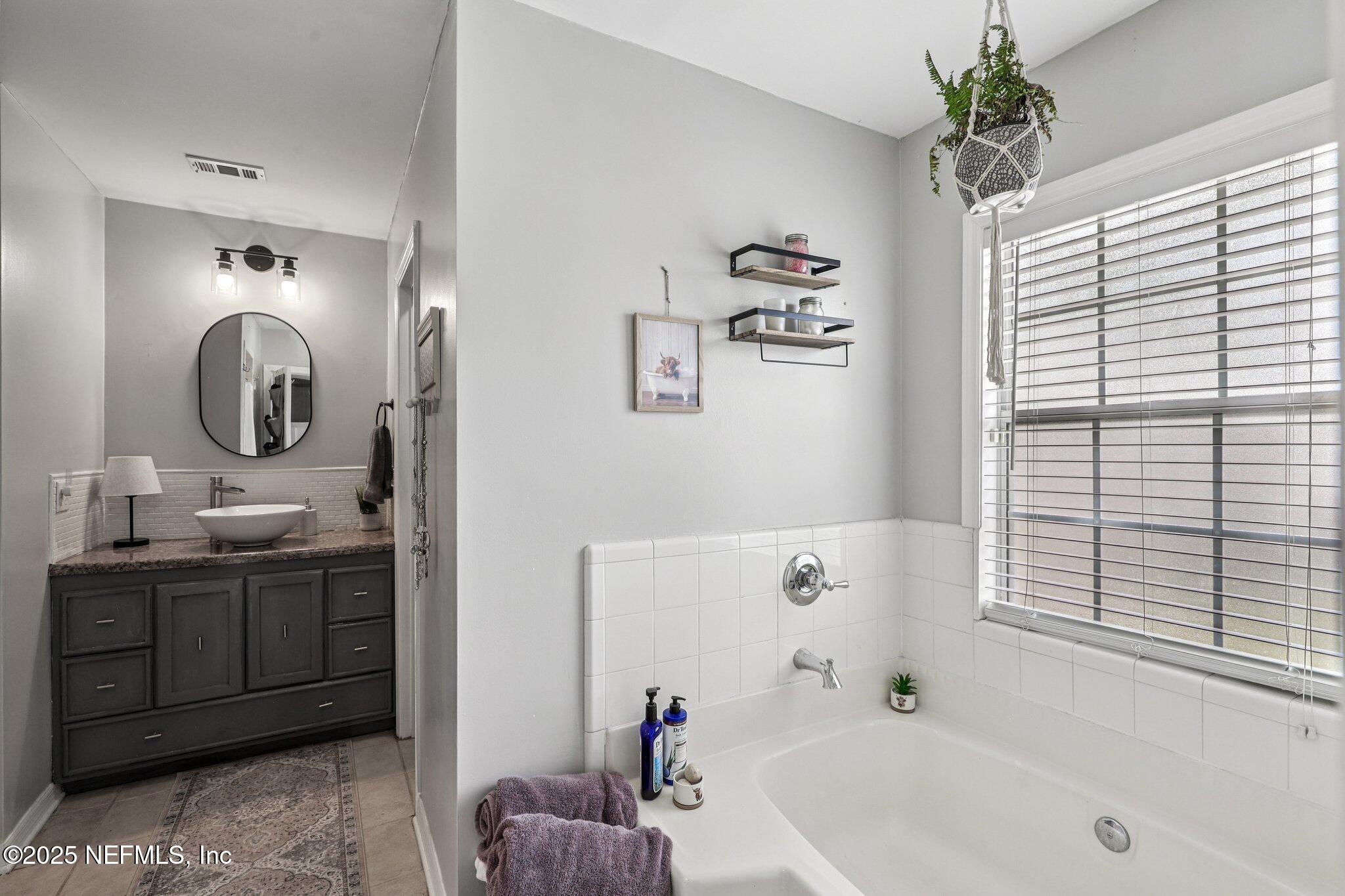 8053 Queensferry Lane Jacksonville, FL 32244 - Photo 20 of 45 a bathroom with a tub sink and mirror