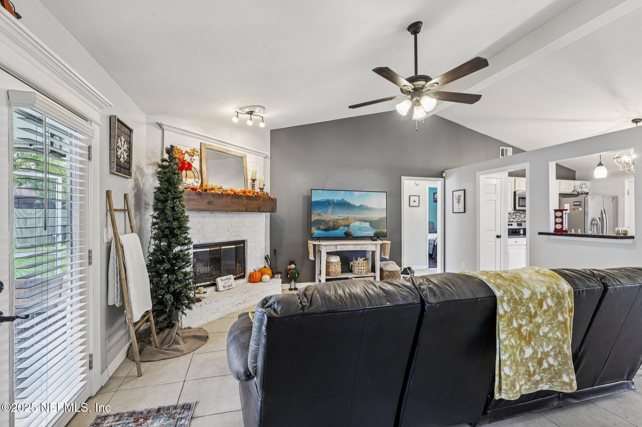 8053 Queensferry Lane Jacksonville, FL 32244 - Photo 8 of 45 a living room with furniture a fireplace and a ceiling fan