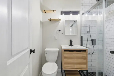 a bathroom with a sink a toilet and shower