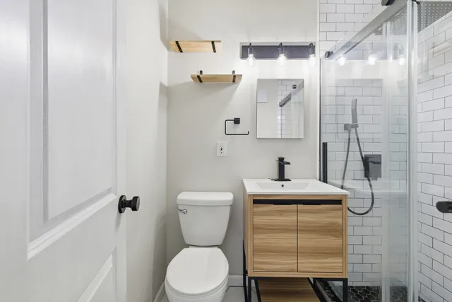 a bathroom with a sink a toilet and shower
