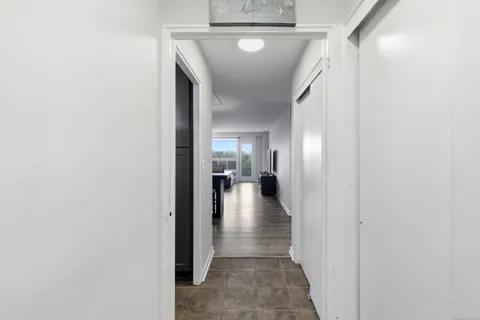 a view of a hallway with wooden floor and a living room