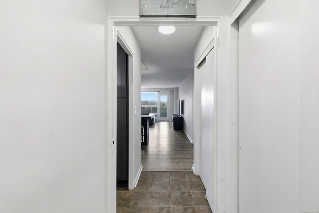 a view of a hallway with wooden floor and a living room