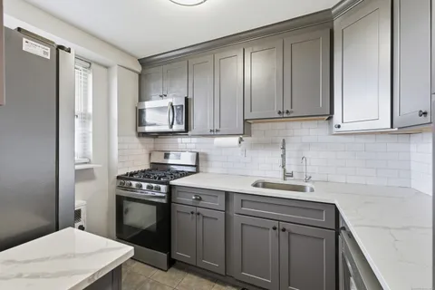 a kitchen with stainless steel appliances a sink stove and refrigerator