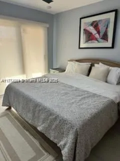 a large bed sitting in a bedroom next to a window