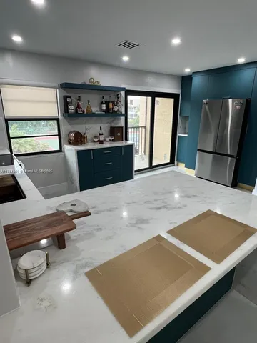 a kitchen with stainless steel appliances a refrigerator sink and stove
