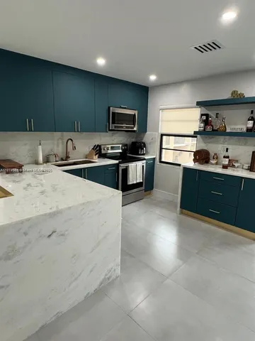 a kitchen with stainless steel appliances kitchen island granite countertop a sink and cabinets